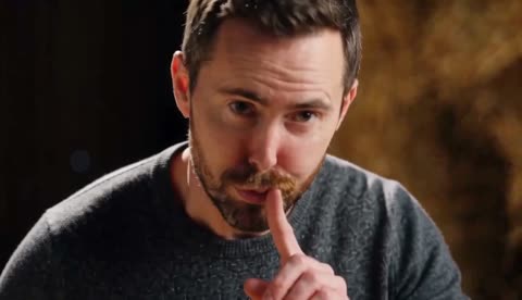 Close-up from our generated recreation showing a man holding a finger to his lips